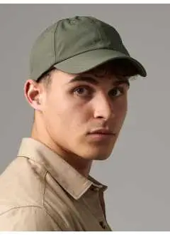 100% nylon Taslon. Casquette 6 panneaux imperméable à l'eau mais perméable à l'air. Visière préformée, bande de sudation 100% polyester Coolmax®. Fermeture par sangle réglable et clip. Etiquette détachable TearAway.