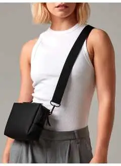 100% poliéster reciclado. Bolso bandolera, tejido repelente al agua, estilo minimalista, apertura con dos cremalleras bidireccionales, bolsillo trasero con cremallera, bolsillo interior de malla, cremalleras de goma, correa de hombro ajustable y extraíble. Tamaño: 20x15x6cm, Capacidad: 1 litro. Correa de hombro: 124cm, Área imprimible: 17x5cm máximo. Etiqueta rasgable.
