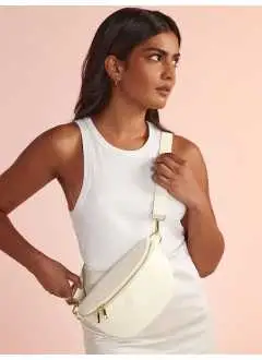 100% PU. Sac de taille avec zip en métal doré haute brillance, support et doublure en PU recyclé. 
Compartiment principal zippé, poche intérieure à glissement et doublure douce au toucher. Bandoulière amovible et réglable. 
Étiquette déchirable.
Compatible avec BG765.