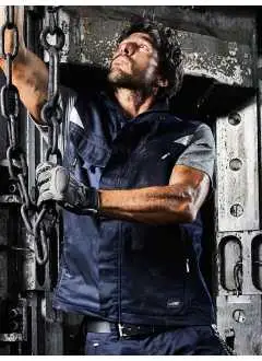 65% polyester, 35% coton. Gilet en tissu durable, col rigide, arrière-col en polaire, bretelles en Cordura au dos, fermeture à glissière intégrale avec protège-menton, ouverture arrière pour la ventilation, poches multifonctions, détails réfléchissants sur le devant et le dos.