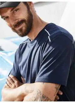 50% cotone, 50% poliestere. T-shirt da lavoro in tessuto misto cotone organico ring-spun e poliestere per un perfetto mantenimento della forma e resistenza al lavaggio, inserti contrastanti sul davanti e sul retro, colletto in elastan, nastro di rinforzo al collo, lavabile a 60° C, ideale per asciugatura in asciugatrice.