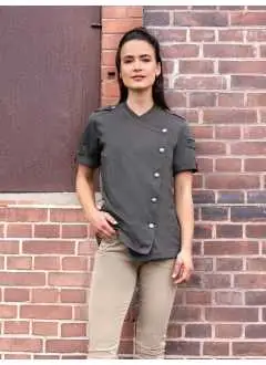 65% poliestere, 35% cotone. Giacca da chef da donna in look jeans con silhouette sottile e maniche corte, 195 g/m². Giacca a 5 bottoni a fila singola chiusa asimmetricamente con bottoni a pressione ROCK CHEF® per apertura e chiusura rapida. Caratteristiche speciali: cuciture rosse a contrasto, toppa con logo sul retro e linguette decorative sulle spalle per un look unico, pratici passanti a sinistra per penne e altri piccoli utensili da cucina. Lavabile fino a 60°C.