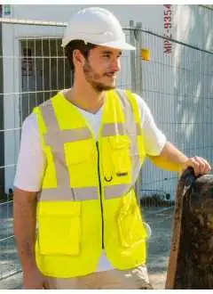 100% polyester. Gilet de sécurité Executive multi-usage. Couleurs jaune et orange conformes à la norme EN ISO 20471:2013 + A1:2016, Oeko-Tex® Standard 100, couleur orange conforme aussi à la norme GO/RT 3279, autres couleurs non conformes à la norme EN ISO 20471:2013 + A1:2016, pas des PPE. Une bande réfléchissante de 5 cm autour du corps, deux bandes réfléchissantes de 5 cm perpendiculaires aux épaules, fermeture frontale à zip, deux poches multi-usage avec fermeture velcro: poche porte-carte d'identité, poche portable, poche stylo et poche porte-clés. Durée des propriétés réfléchissantes correspondante à 25 cycles de lavage à 40°C, conformément à la norme EN. Emballage individuel en polyéthylène.