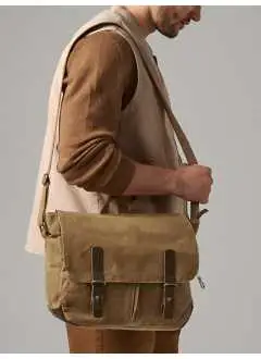 100% cotone canvas cerato resistente all'acqua. Borsa a tracolla con dettagli in vera pelle, scomparto principale con zip, due tasche frontali, chiusura con bottoni automatici, rifiniture effetto ottone anticato, completamente foderato, può contenere laptop fino a 14