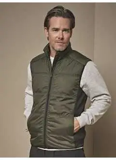 Extérieur: 100% polyester 300T. Panneaux contrastés: 90% polyester, 10% élathanne. Intérieur: 100% polyester 380T. Bodywarmer bi-matière- Isolation DuPont™. 2 poches avant zippées dissimulées. Panneaux latéraux stretch